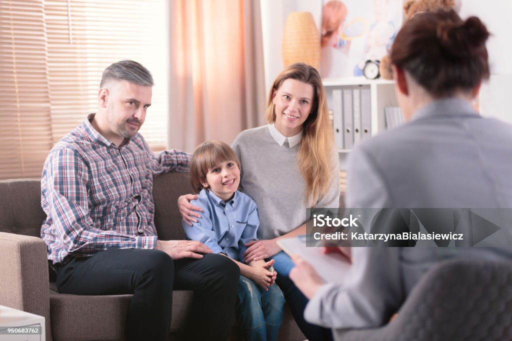 Smiling son with happy parents Smiling son with parents during consultation with advisor Family Stock Photo