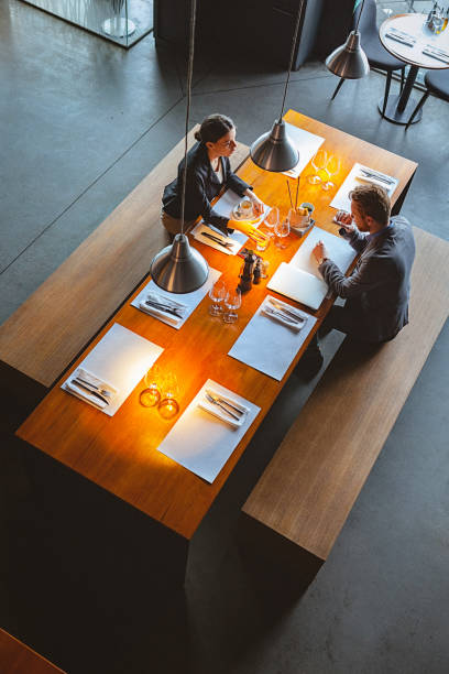 High Angle view of a Man and Woman Having a Conversation During Lunch Time in a High-End Restaurant stock photo
