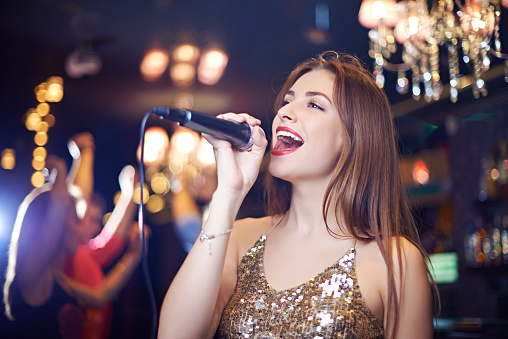 Attractive pop star singing in night club