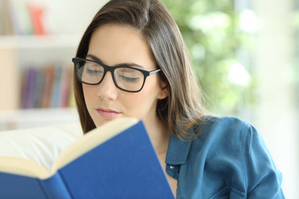 istock Woman wearing eyeglasses reading a paper book 950689984