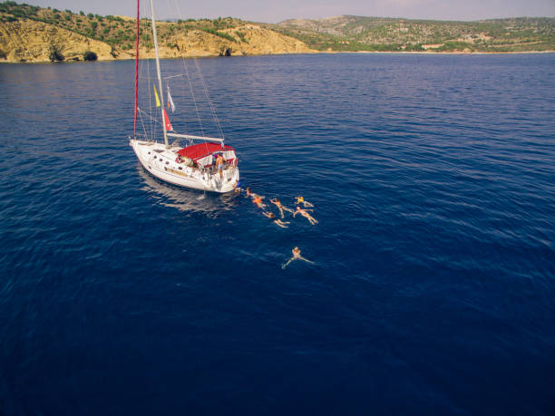 istock People on vacation swimming around sailboat 950690750