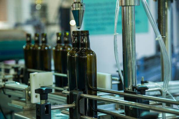 Botellas en banda transportadora en fábrica - foto de stock