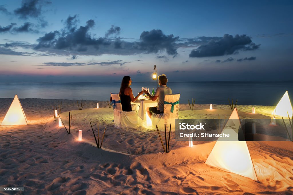 Honeymoon couple is having a private, romantic dinner Honeymoon couple is having a private, romantic dinner at a tropical beach Beach Stock Photo