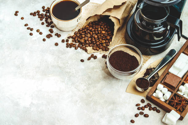 istock Variety things for prepare coffee. Roasted beans, ground coffee, scoop, electric coffee machine and assortment of sweets and spices to eat with on light background. Top view copyspace 950699238