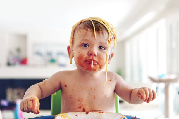 baby jongen eten spaghetti - jongen peuter eten stockfoto's en -beelden