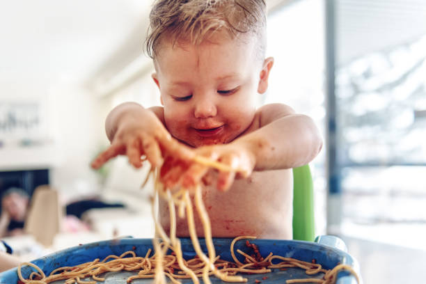 baby boy comer espaguetis - baby food fotografías e imágenes de stock