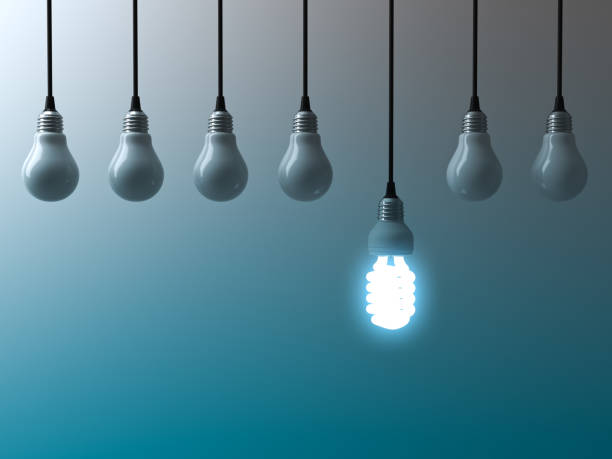 istock One hanging eco energy saving light bulb glowing and standing out from unlit light bulbs on dark green blue background , leadership and different creative idea concept. 3D rendering 950706782