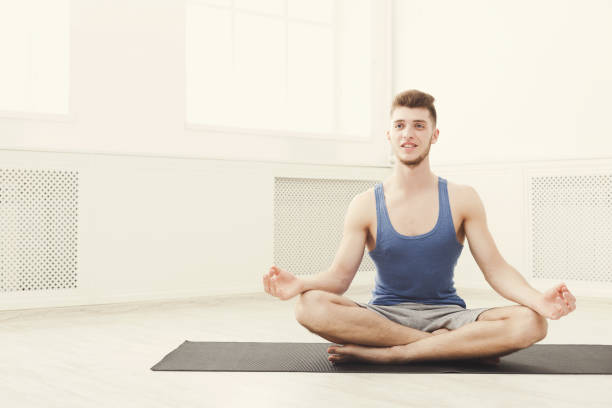 istock Man training yoga in lotus pose, copy space 950706832