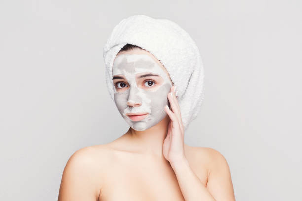 istock Beautiful girl with applied clay mask at white background 950713080