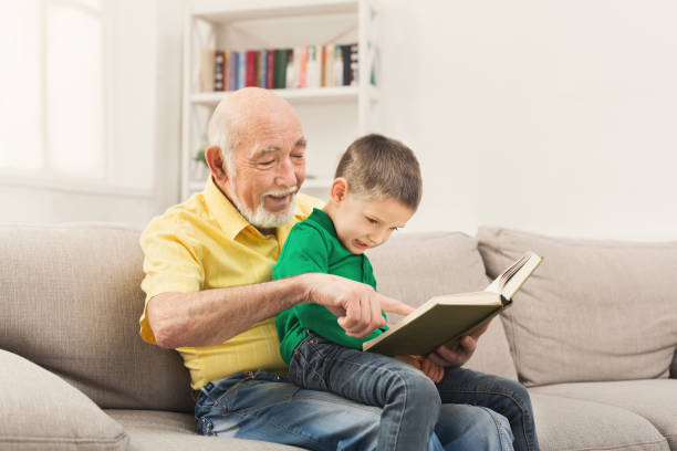istock Senior man reading book for his grandchild 950722790