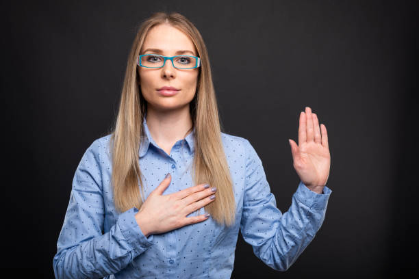 Business lady wearing blue glasses making oath gesture stock photo