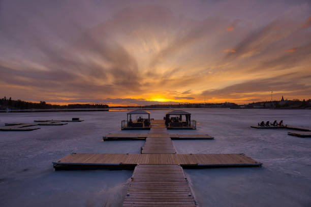 Sunset over frozen lake Sunset behind the frozen lake with pier in Kenora, Ontario kenora stock pictures, royalty-free photos & images