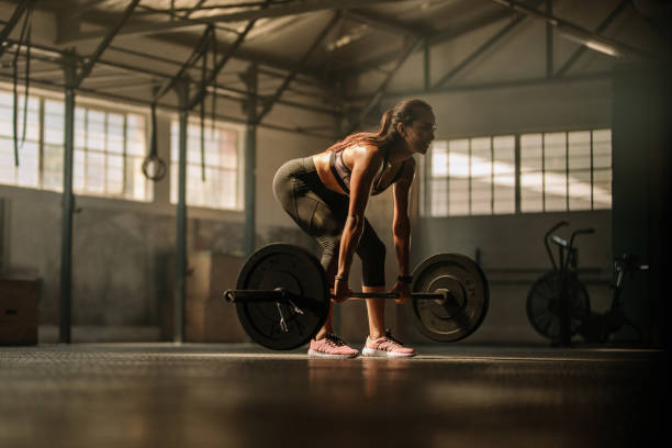 istock Fitness model performing weight lifting exercise at gym 950733656