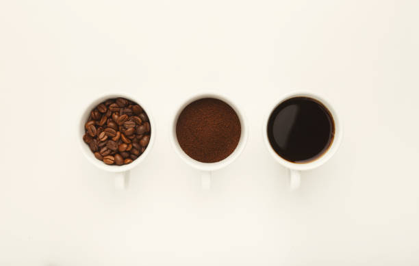 istock Roasted whole and ground coffee beans in cups, top view, white i 950736864