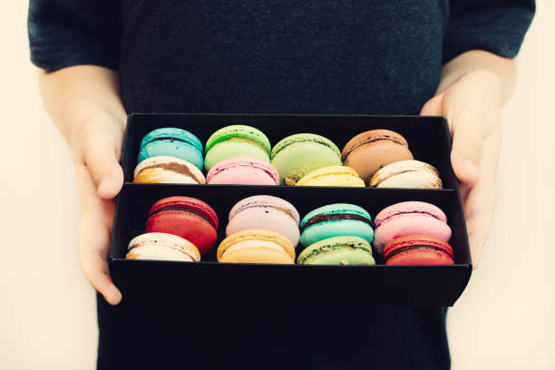 istock Boy holding dessert macarons in black wooden box. 950739306