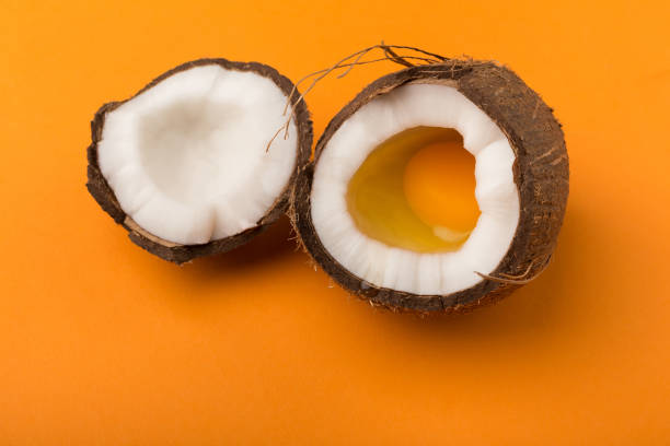 istock Coconut half with egg yolk inside at yellow background 950740082