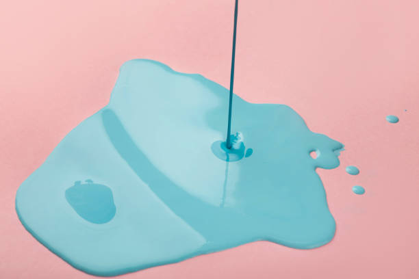 Blue paint flowing on pink background