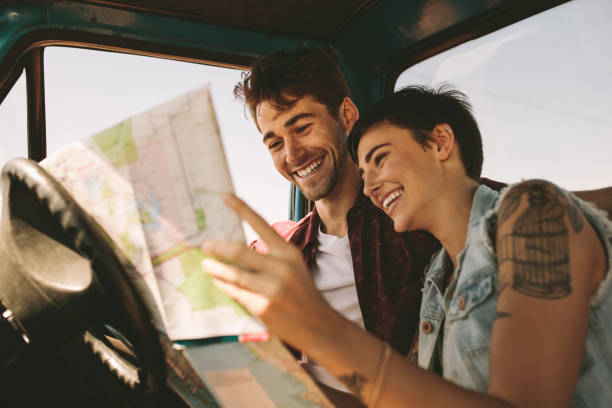 istock Young travellers on a road trip looking at map 950742974