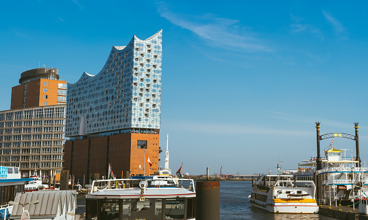 Hamburg, Germany - May 17, 2018: Panorama of hafencity - blue sky bright sky, business trade buildings. Some tourist boats in foreground, Hamburg, Germany.