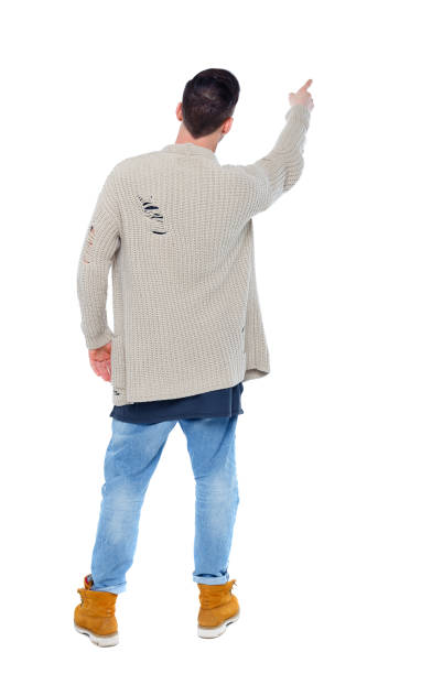 istock Back view of a stylish man in a knitted sweater points his hand upwards. 950746862