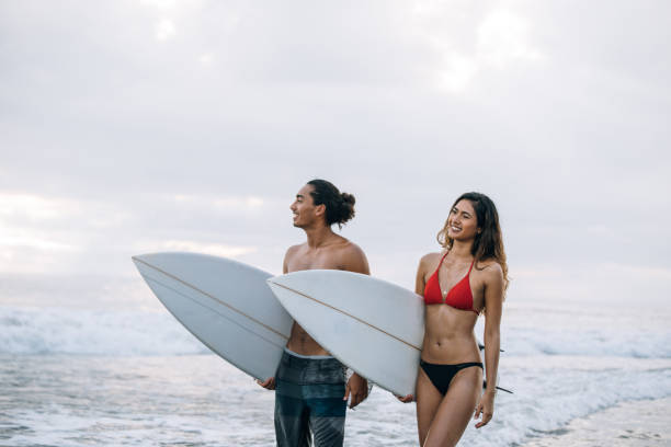 istock Young couple surfing together 950764420