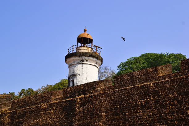 istock Old colonial lighthouse and old fortress wall 950767000