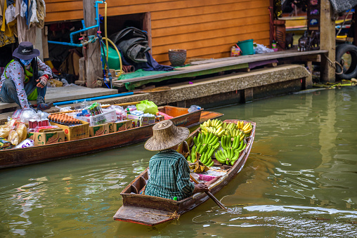 Damnoen Saduak, Thailand - April 1, 2018 : Local seller  with bananas at a famous floating market near Bangkok in Thailand.