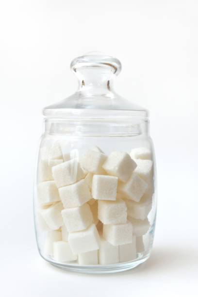 istock Glass jar with lump sugar on white background 950773554