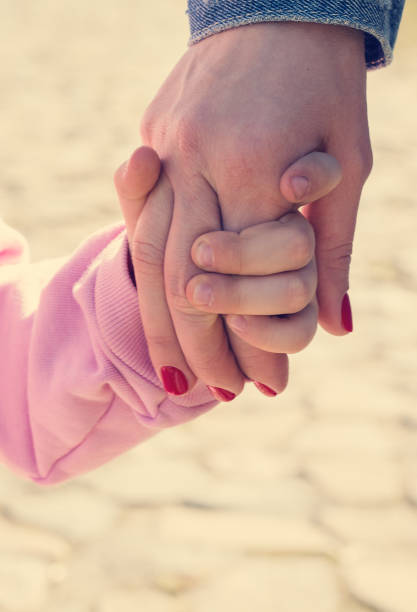 istock child holds mother hand 950776130