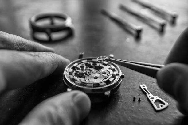 l'orologiaio sta riparando gli orologi meccanici nella sua officina - watch maker work tool repairing watch foto e immagini stock