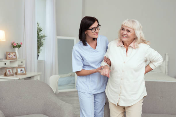 istock Merry nurse assisting elder woman 950779606