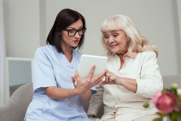 istock Positive elder woman trying to use tablet 950779900