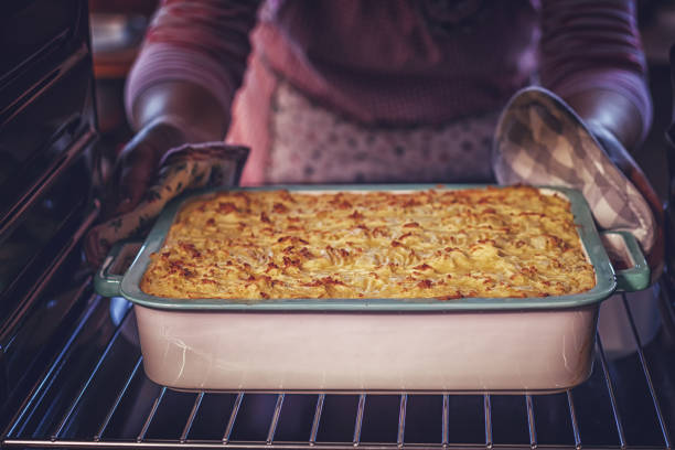 baking traditional shepard`s pie in the oven - english tomato imagens e fotografias de stock