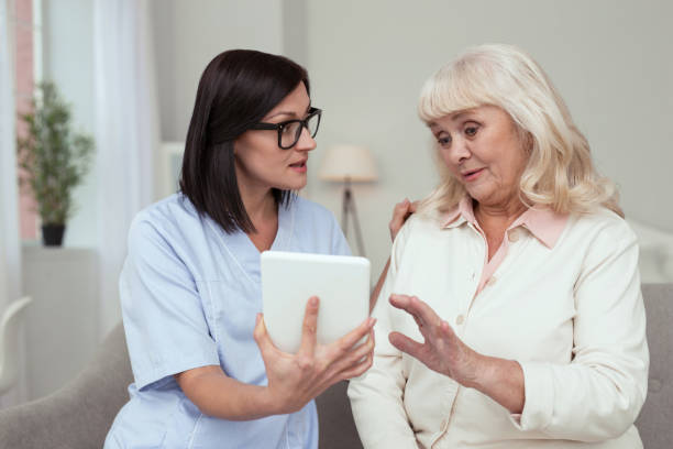 istock Focused nurse showing tablet to elder woman 950780020