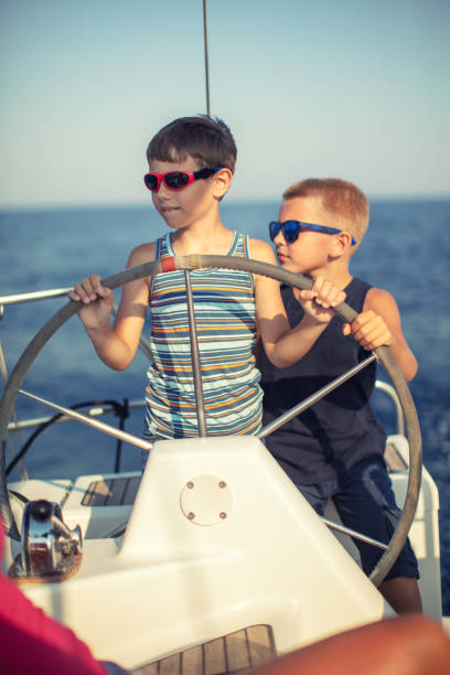 istock Two boys steering with sailboat 950780154