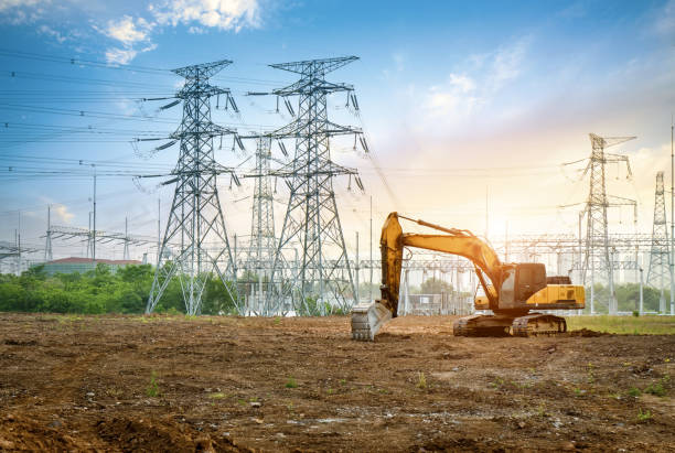 la excavadora es en la obra, lejos de pilas eléctricas y subestaciones. - earth mover digging land bulldozer fotografías e imágenes de stock