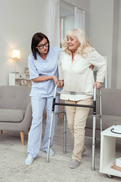 istock Careful nurse cheering elder woman 950783680