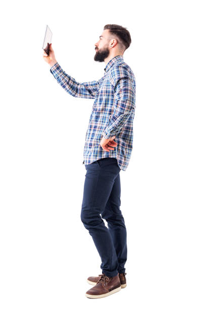 istock Side view of bearded young business man holding up pad tablet computer 950784652