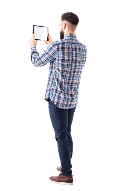 side back view of young business bearded man holding pad tablet computer taking photo. - over the shoulder view fotos imagens e fotografias de stock