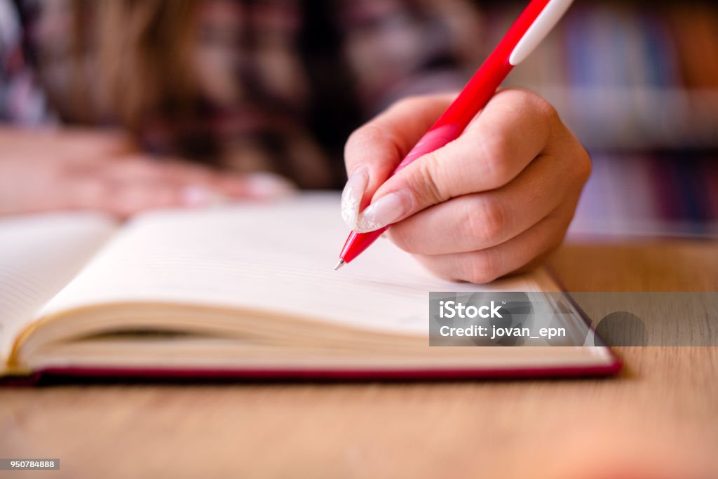 At university class Cut out of student writting notes in her notebook. 20-24 Years Stock Photo