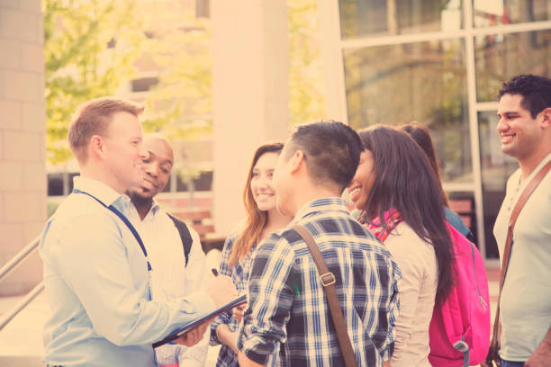 istock College recruiter gives campus tour to potential students. 950785112
