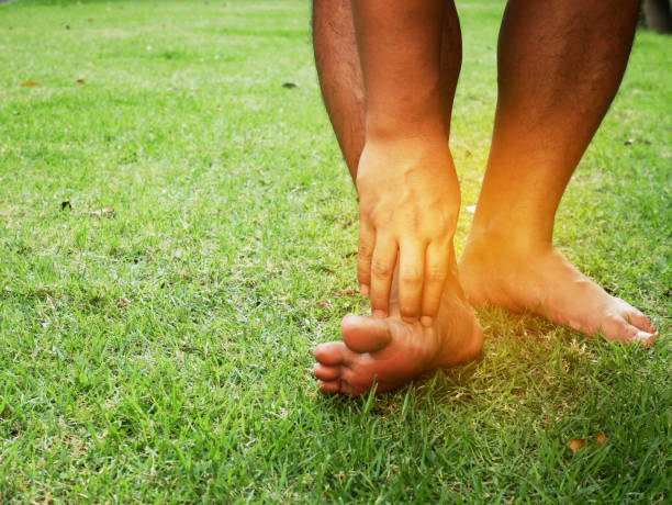 prurito dal fungo dei piedi sull'erba nel parco. - podiatry human foot grass barefoot foto e immagini stock