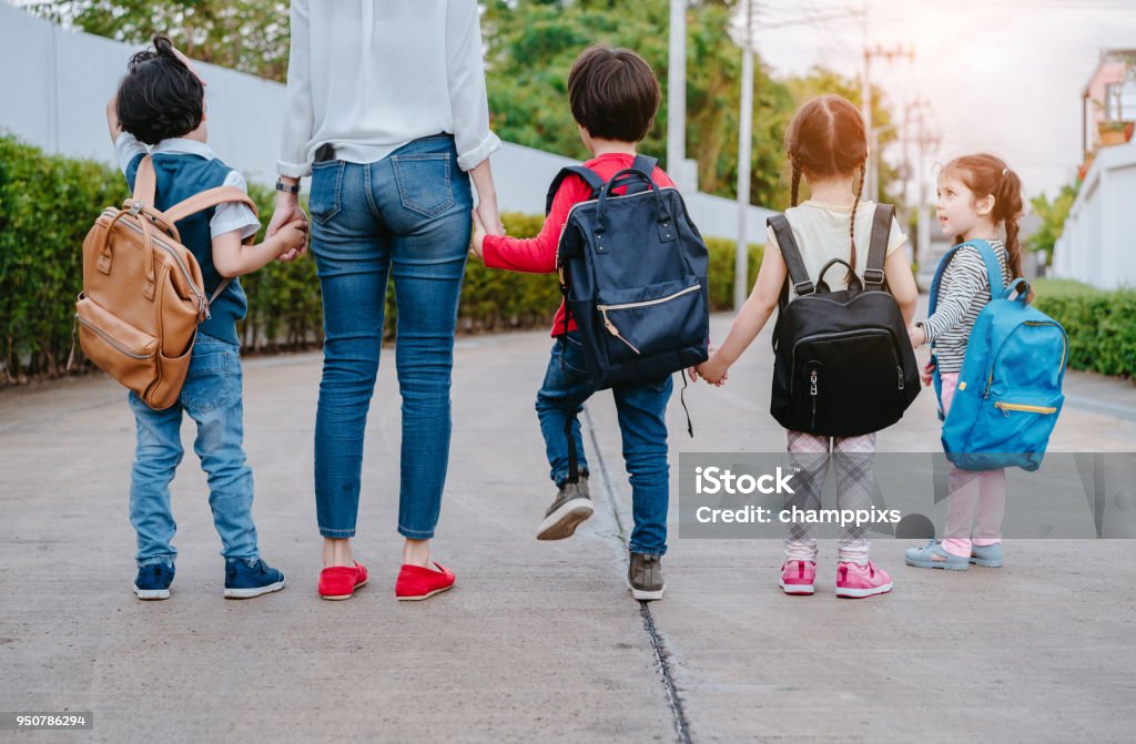 Mother and pupil and kids holding hands going to school in first class with schoolbag or satchel walking to school bus, Parent and son,sister preschool Back to School Stock Photo