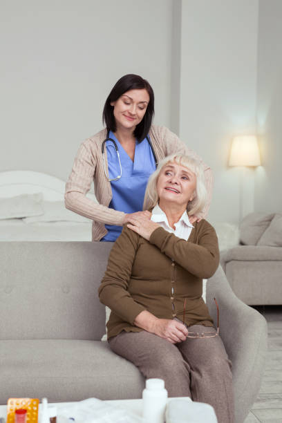 istock Glad nurse massaging elder woman shoulders 950787592