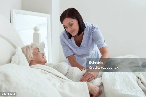 Appealing Glad Nurse Setting Pain Area Stock Photo - Download Image Now - Home Caregiver, Baby Boomer, Healthcare Worker