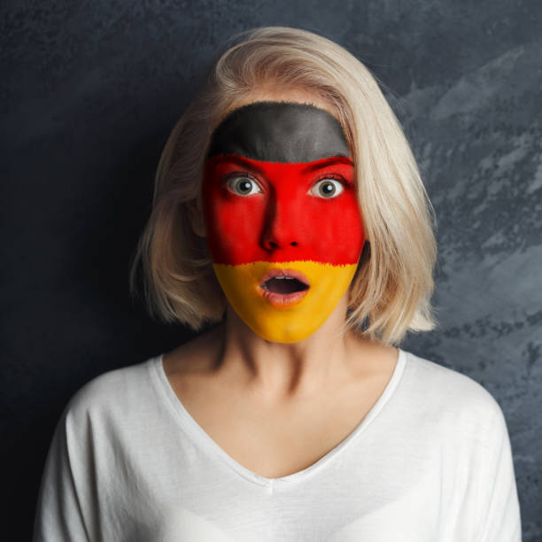 istock Young woman with Germany flag painted on her face 950788462