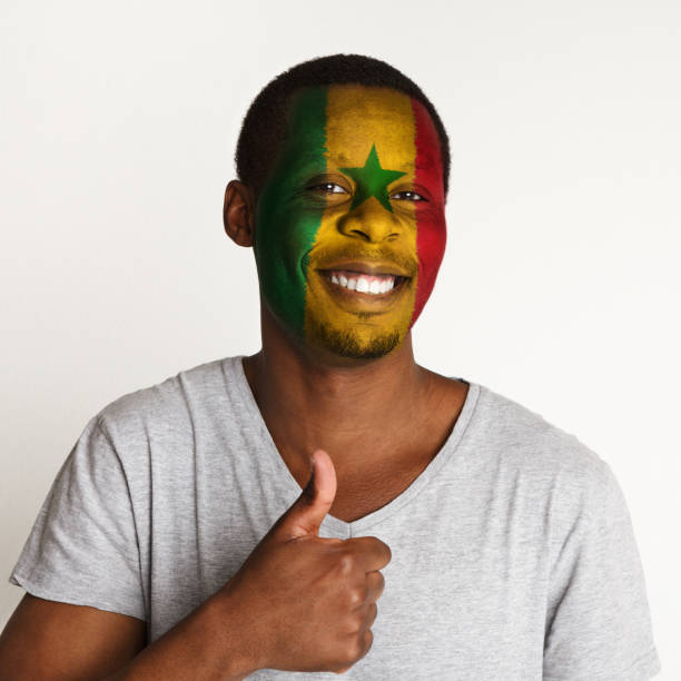 istock Young man with Senegal flag painted on his face 950791296