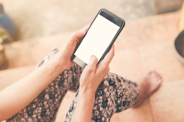 istock Close up hand woman holding and using phone in garden. 950801996