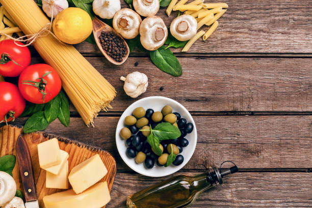 istock Ingredients for spaghetti with basil, tomatoes, cheese on wooden background, top view, place for text 950811078
