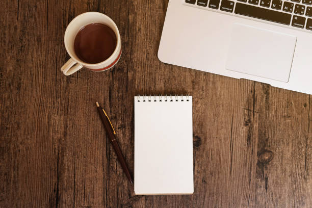 istock Office desk with laptop, coffee, notebook and pen. Top view with copy space. 950815844